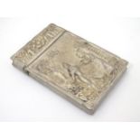 A Eastern white metal card case decorated with scenes depicting people and deity like figures.