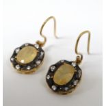 A pair of gold and gilt metal drop earrings set with yellow semi precious facet cut central stones