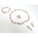 A gold and pearl suite of jewellery comprising necklace, bracelet, drop earrings and ring.