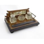 A Late Victorian walnut Standish with bevelled mirror back, glass inkwells and nib holder.