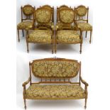 A Louis XVI style walnut salon suite to include a settee, two armchairs, and four side chairs.