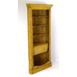 A late 18thC / early 19thC pine corner cupboard with moulded cornice above shaped shelves and drop