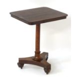 A William IV mahogany occasional table with a rectangular top, turned stem and triform base,