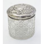 A cut glass dressing table jar with embossed silver top hallmarked Birmingham 1902 maker William J