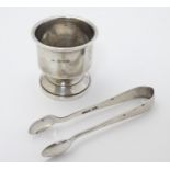 A silver egg cup hallmarked Birmingham 1944 together with sugar tongs hallmarked Sheffield 1919 (2)