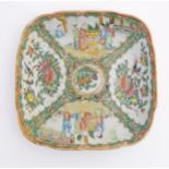 A Cantonese famille rose square dish with hand painted decoration in panels depicting figures,