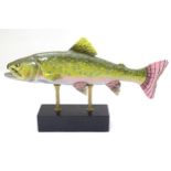 A large hand painted ceramic figure in the form of a trout on a display stand,