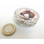 A pill box of ovoid form having enamel cabochon to lid, depicting a horses head,