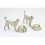 A pair of silver plate novelty table salts formed as dogs before bowls.