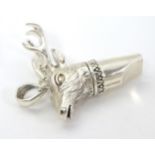 A 21stC silver novelty whistle with stag head decoration.