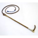 Hunting: a late Victorian medium hunting whip by Brigg, of plaited brown leather with hazel shaft,