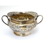 Matching to previous lot : A silver sugar bowl with twin handles and embossed decoration,