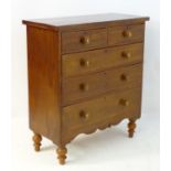 A Victorian chest of drawers comprising two short over three long graduated drawers with turned