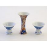 A pair of Japanese porcelain sake cups advertising Hakutsuru, decorated with flying cranes.