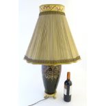 An early 20thC ceramic electric table lamp with ormolu and hand painted decoration including sirens,