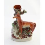 A Staffordshire flat back spill vase formed as a tree trunk with a fox and a goose on an oval base.