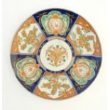 An Imari charger decorated with panels depicting flowers and foliage with gilt highlights. Approx.