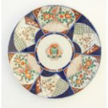 An Imari charger decorated with panels depicting flowers and foliage with gilt highlights. Approx.