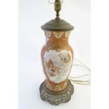 A Japanese Kutani lamp base with panel decoration to the front and back,