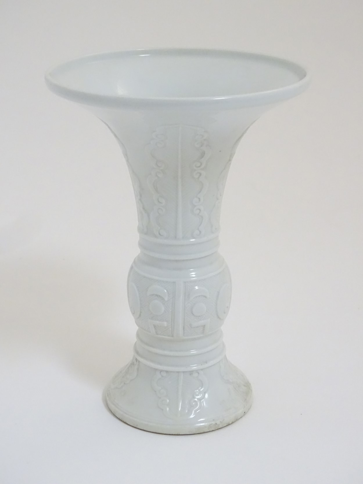 A Chinese white glazed Gu vase of archaic bronze design,