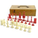 A turned bone and stained red bone chess set, largest approx. 2 3/4". Contained in a wooden box.