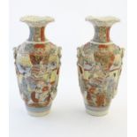 A pair of Japanese Satsuma vases, decorated with figures in a lavish interior,