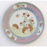 A Chinese famille rose plate decorated with three quails, a butterfly and peonies,