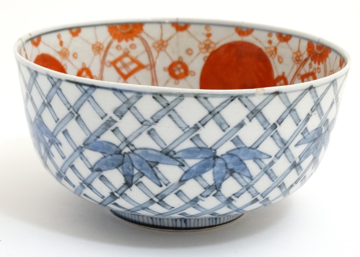 A Chinese blue and white bowl decorated with stylised bamboo and foliage to outer ,