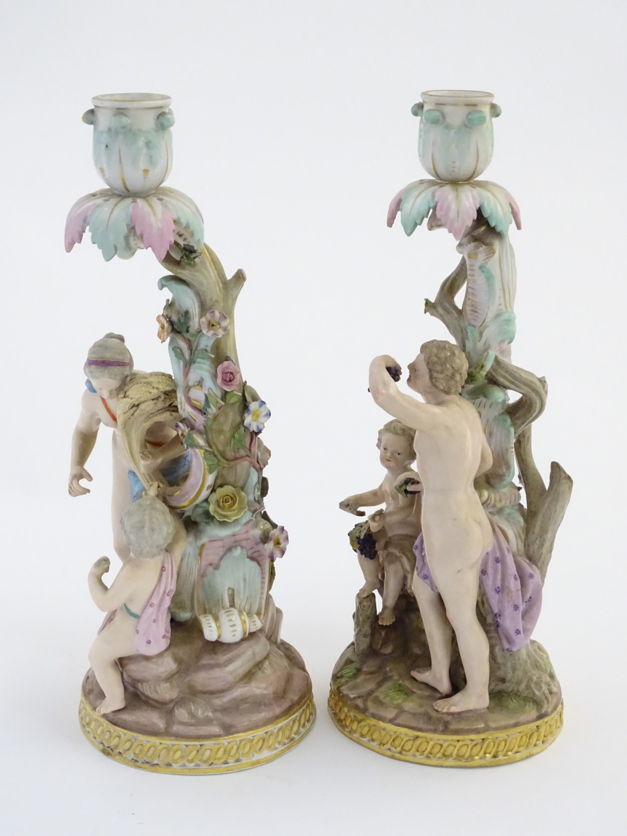 Two Meissen porcelain candlesticks, one depicting Bacchus and a child with vines and grapes, - Image 3 of 7