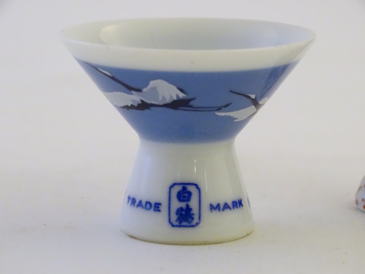 A pair of Japanese porcelain sake cups advertising Hakutsuru, decorated with flying cranes. - Image 3 of 8