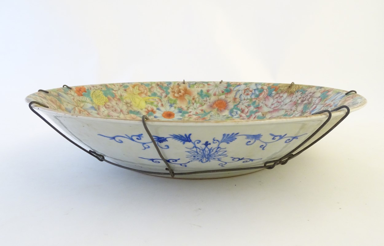 An Oriental bowl decorated with stylised flowers, with a scrolling blue floral design to reverse. - Image 4 of 5
