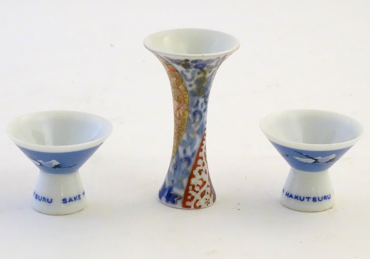 A pair of Japanese porcelain sake cups advertising Hakutsuru, decorated with flying cranes. - Image 5 of 8