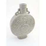 A large Chinese crackle glaze celadon twin handled moon flask having central medallion surrounded
