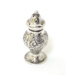 A Victorian silver pepperette with embossed decoration.