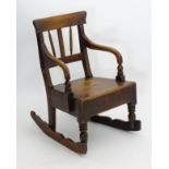 An early / mid 19thC elm and oak childs rocking chair with figured elm top rail,