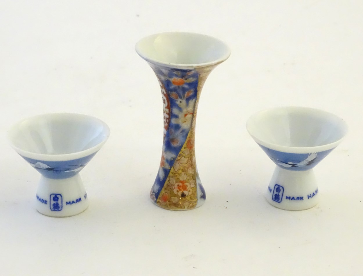 A pair of Japanese porcelain sake cups advertising Hakutsuru, decorated with flying cranes. - Image 4 of 8