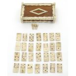 A set of miniature carved bone prisoner of war dominoes and 4 bone cribbage pegs contained within a