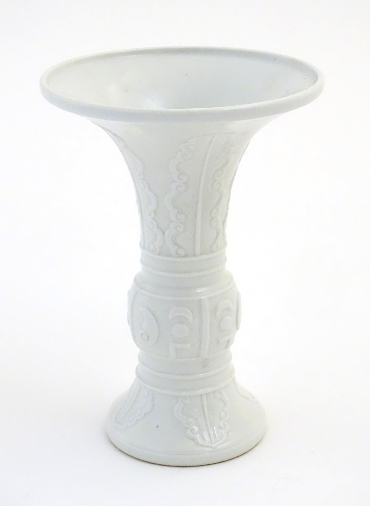 A Chinese white glazed Gu vase of archaic bronze design,