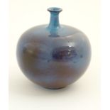 A high fired globular vase with a flared rim. Approx. 9 1/2" high.