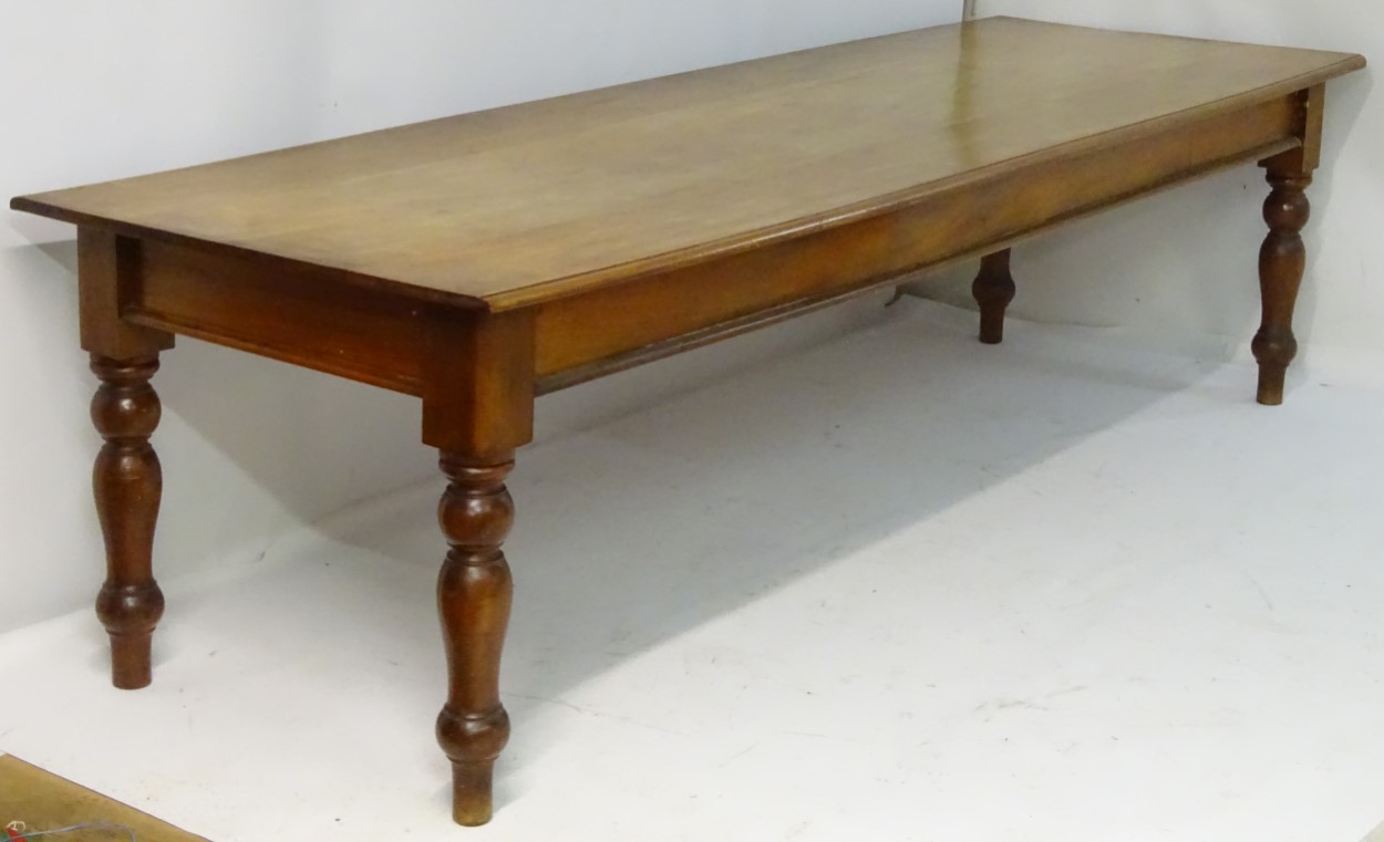 A late 19thC mahogany boardroom table / dining table standing on turned tapering legs.