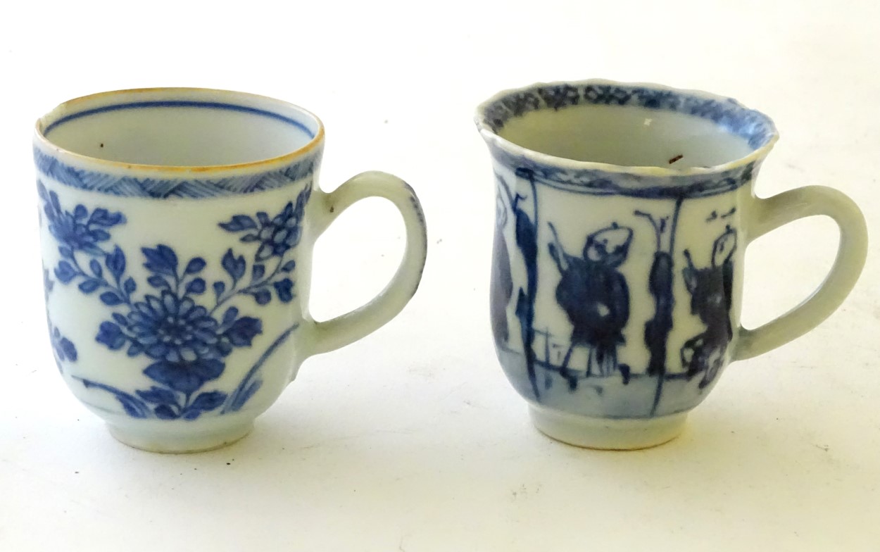 Two Chinese blue and white teacups, one decorated with flowers and foliage, the other with figures.