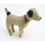 A mohair wood shaving stuffed dog toy, with collar, plastic eyes and a stitched mouth and nose.