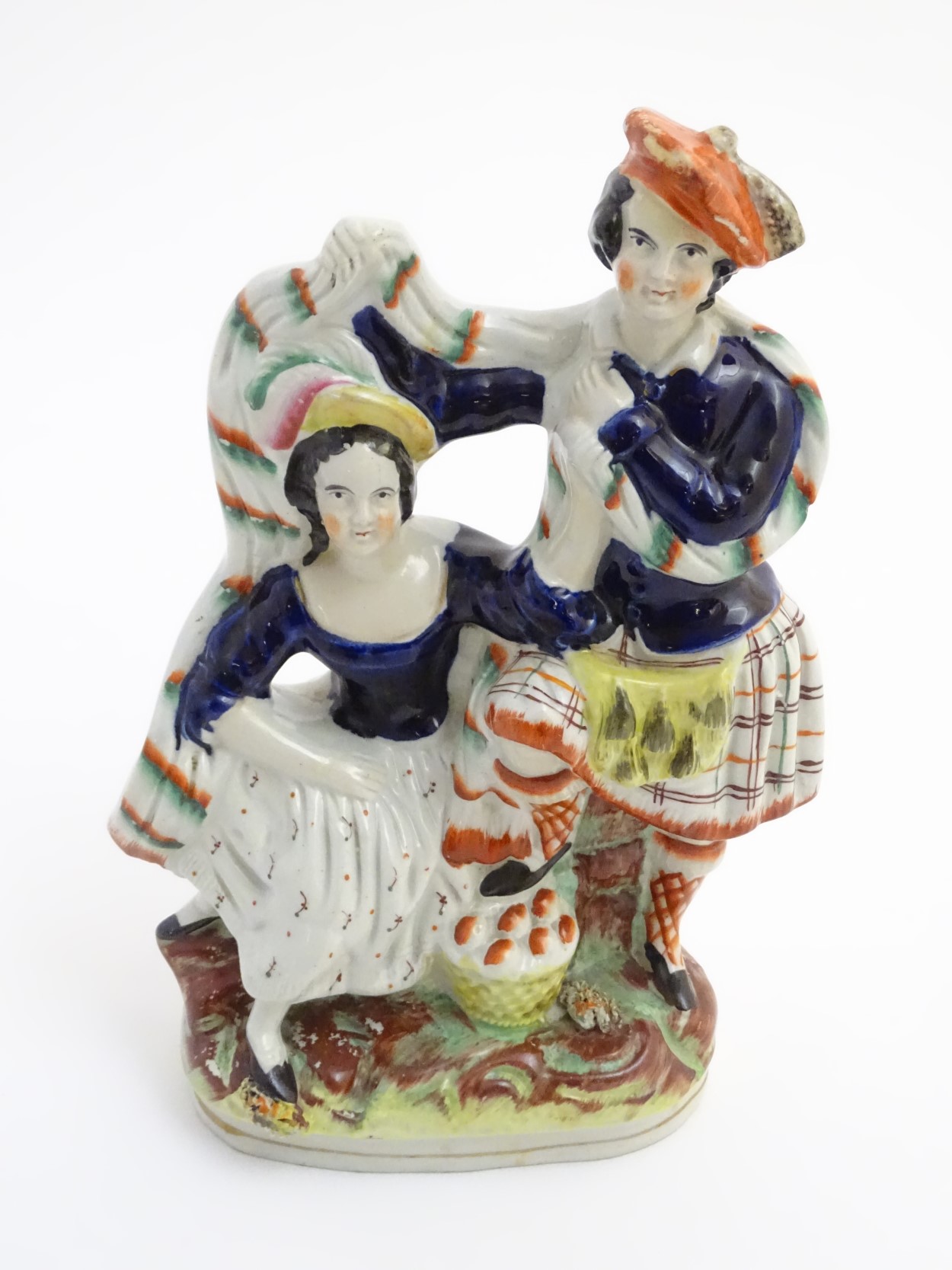 A Victorian Staffordshire pottery figural group of a man and a woman in highland dress,