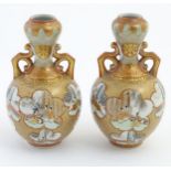 A pair of Japanese Kutani Satsuma vases with decorative handles,