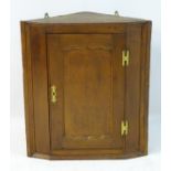 A late 19thC / early 20thC yew wood corner cupboard with H bracket hinges,