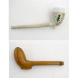 An 18thC carved fruit wood pipe case opening to reveal a clay pipe having green glazed beetle