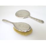 A silver backed hand mirror and brush with engine turned decoration.