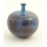 A high fired globular vase with a flared rim. Approx. 9 1/2" high.