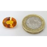 Unmounted stone: An orange oval cut sapphire, approx 9.
