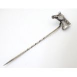 A white metal stick pin surmounted by a horses head.